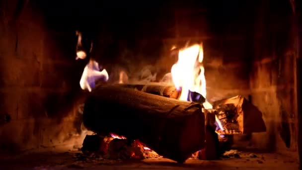 寒い季節の自宅での暖かさと快適さ 火災や火災で木製のログを吸う 木が石の暖炉で燃えている クローズアップ — ストック動画