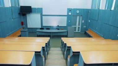 Boş oditoryum. Üniversitedeki modern konferans salonu. Tahta önünde ahşap masalar ve konferans salonunda multimedya panosu.