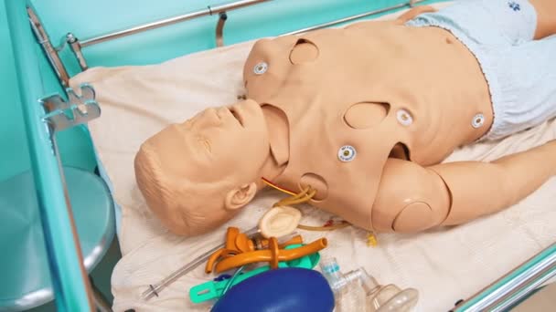 医学実践を教えるためのダミーモデル 医学大学の研究室で病院のベッドに横たわる男のマネキン人形 — ストック動画