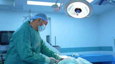Doktor aşırı kilolu hastaya ameliyat yapar. Profesyonel cerrah hastanın vücudundan yağ pompalıyor. Yağ aldırma. Profil görünümü.