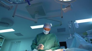 Abdominoplasti ameliyatı. Deneyimli cerrah yağ pompalamak için ameliyat yapıyor. Aşağıdan bak. Hastanede ameliyat ve resüsitasyon.