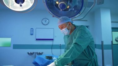 Modern klinikte liposuction prosedürü. Profesyonel doktor, tıbbi lambaların altında hastanın vücudundan yağ pompalıyor. Klinikte estetik ameliyat.
