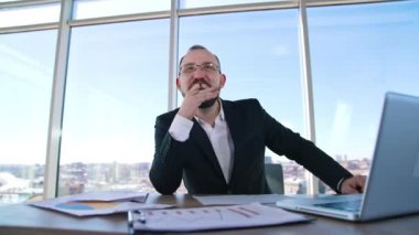 Gülümseyen patron masada oturuyor. Takım elbiseli sakallı iş adamı ofisteki biriyle olumlu konuşuyor ve gülümsüyor. İş konsepti.