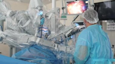 Robotik ekipmanlarla minimal invaziv ameliyat. Profesyonel cerrah ameliyathanedeki ekranda mikro cerrahi işlem gözlemliyor..
