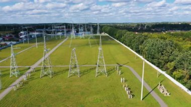 Elektrik kuleleri olan bir alanda panoramik manzara. Kırsal kesimdeki yeşil doğanın arka planında kabloları olan yüksek voltajlı elektrik hatları..