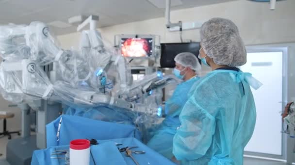 ロボットマシンを搭載した病院の外科室 医師はスクリーンの外科手術を観察する 医療用ロボットによる侵襲性手術 — ストック動画