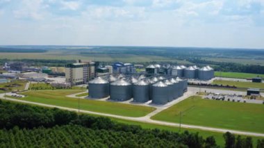 Sahada modern bir bitki. Zirai ürünleri işlemek için tarım ve imalat tesisinde gümüş silolar. Hava görüntüsü. Hareket kamerası geri.