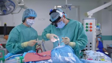 Asistan ve cerrah ameliyathanede. Profesyonel doktor ve hemşire steril tıbbi gereçlerle burun ameliyatı yapıyorlar..