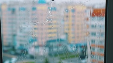 Pencere fırçayla temizleniyor. Dairenin içindeki özel aletle temiz suyla yıkanan bardaklar. Profesyonel pencere temizleme servisi. Yakın plan..