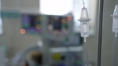 Klinikteki arka planda damar içi damlama. Ameliyathanede ilaçlı bir damlatıcı var. Yakın plan..