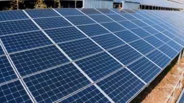 Güneş ışınları yenilikçi güneş hücrelerini yansıtır. Mavi fotovoltaik güneş panelleri güneşten temiz enerji alırlar. Yeşil alternatif enerji.