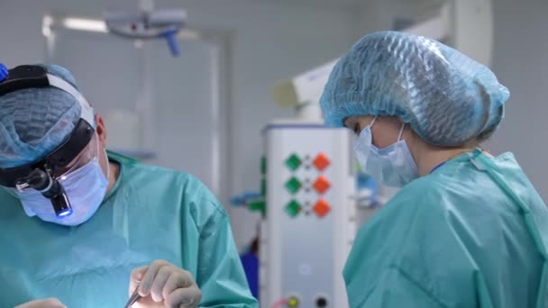전문가에 수술을 조수와 외과의사요 의사는 기기를 사용합니다 클로즈업 — 비디오