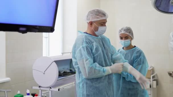 Los Especialistas Médicos Preparan Para Cirugía Ayudante Ayudando Usar Una — Vídeos de Stock