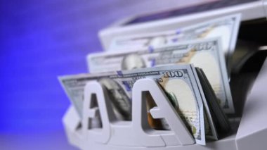 Bankada yüz dolarlık banknotları saymak. Modern bir elektronik para sayma makinesinde finansal işlem. Kağıt para saymak için otomatik ekipman.