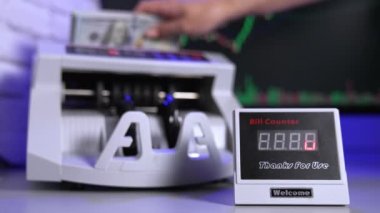 Masada modern para sayma makinesi var. El, elektronik makineye büyük miktarda kağıt para harcıyor..