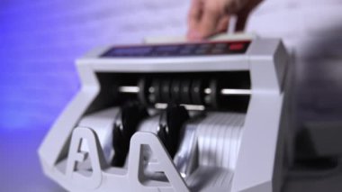 Elektronik makine yüz dolarlık banknotları sayıyor. Kağıt para saymak için modern otomatik ekipman. Bankacılık ve ticari faaliyetler için para sayma makinesi. Yavaş çekim.