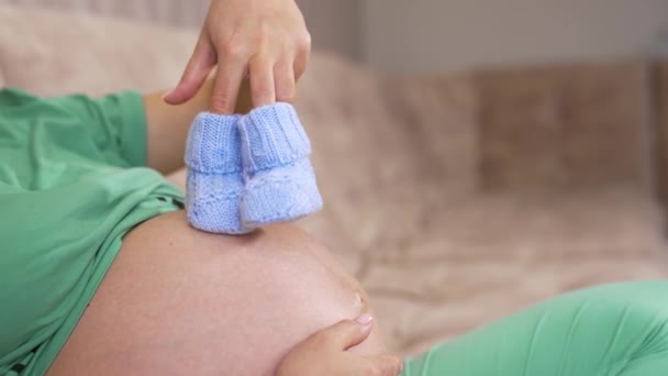 Gravid Kvinna Och Håller Små Strumpor För Framtida Barn Sidovy — Stockvideo