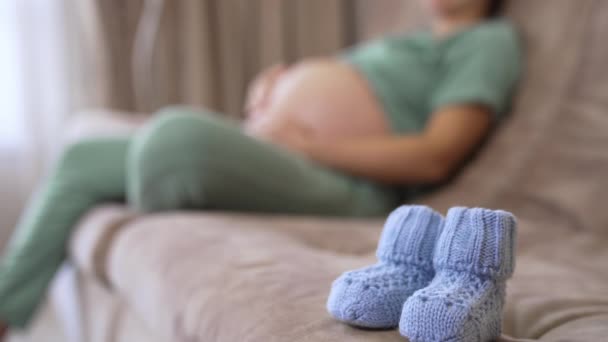 Schöne Kleine Gestrickte Socken Für Zukünftige Kinder Babysocken Auf Verschwommenem — Stockvideo