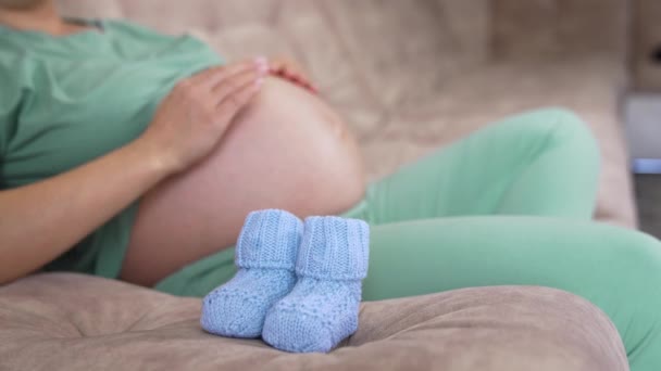 Schwangere Mit Nacktem Bauch Hause Schöne Gestrickte Blaue Babysocken Auf — Stockvideo