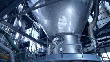 Büyük süt işleme tesisi. Fabrikanın içinde süt ürünleri üretmek için modern metal ekipmanlar var. Süt ürünleri üretim tesisi.