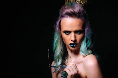 Mavi saçlı ve kafasında taç olan kadın. Göz alıcı bir kadın, parlak mavi saçları ve kafasının tepesinde kraliyet tacı var..