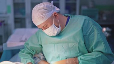 Ameliyathanede ameliyat sırasında doktor. Yeni tıbbi ekipmanların yardımıyla cerrahi işlem.