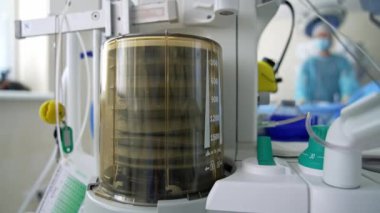 Anestezi makinesi vantilatörü. Doktorların bulanık geçmişinde hastanın hayatını kurtarmak için tıbbi ekipman. Yakın plan..