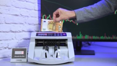 Sayma makinesine Euro para birimi. Makinede 50 Euro 'luk banknotlar sayılıyor. Sayma mekanizması avro işliyor.