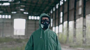 Kimyasal koruyucu giysili biri dikkati dağılmış bir yerde duruyor. Yıkılmış binaların çöp yığınlarıyla terk edilmiş bir yerde hayatta kalan biri. Kıyamet kavramı