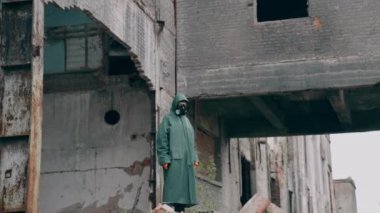 Gezegenimizi kurtarın. Terk edilmiş bir yerde duran koruyucu maske takan bir insanın hareket kamerası görüntüsü. Çevre kirliliği, ekolojik felaket, nükleer savaş, kıyamet sonrası kavramı