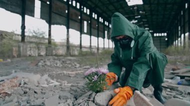 Gezegenimize yeni bir hayat vermek. Güvenlik giysisi ve gaz maskesi takmış bir ekolojist. Binanın etrafındaki çöplüğe çiçek koymaya hazırlanıyor. Biyokimyasal saldırı konsepti