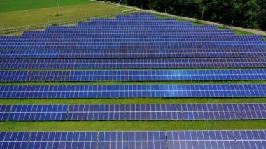 Güneş pili panelleri alanı. Mavi güneş panelleri temiz enerji için çiftliktir. Yeşil alanda uzun, güneşli bataryalar. Yenilenebilir alternatif enerji kavramı. Gelecekteki teknoloji konsepti
