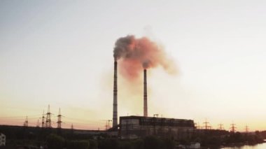 Yüksek voltajlı gökyüzü arka planının statik görüntüsü, üzerinde duman olan fabrika borusu. Dünya kirliliği ve sanayileşme kavramı. Seçici odak