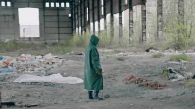 Doğa tehlikede. Güvenlik giysisi ve gaz maskesi takmış bir ekolojist terk edilmiş yerlere çiçek yerleştirmeye hazırlanıyor. Biyokimyasal saldırı ve kirlenmiş çevre konsepti
