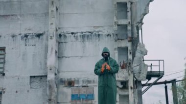 İnsan solunum cihazında yıkılmış binaya bakıyor ve çalışmaya hazırlanıyor. Biyolojik saldırı konseptinden sonra terk edilmiş bir yerde ekolojist.