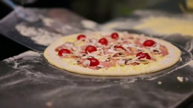 Pizzacı pizza yapıyor. Şef pizza spatulasını kullanarak pizzayı fırına veriyor. Gıda hazırlama konsepti