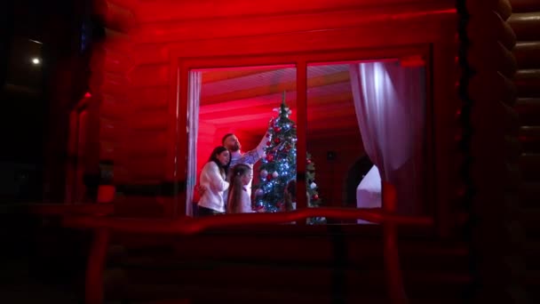 Utsikt Fra Gaten Til Den Ekstremt Lykkelige Familien Dekorert Juletre – stockvideo