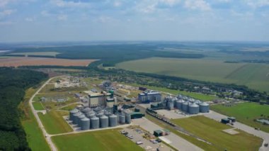Doğadaki yenilikçi tarım fabrikası. Yazın yeşil alanda modern tahıl ambarı asansörleri. Çelik ambar. Hava görünümü