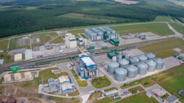 Sahada tahıl asansörleri olan sanayi fabrikası. Güzel doğa manzarasının arka planında tarım hasat deposu var. Hava görünümü