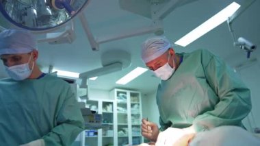 Ameliyathanede cerrahların işi. Tıp üniformalı doktorlar yağ çıkarmak için cerrahi bir prosedür uyguluyorlar. Klinikte yağ aldırma