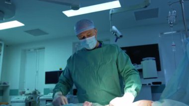 Doktor ameliyathanede liposuction yapıyor. Karın bölgesindeki aşırı yağı çıkarmak için cerrahi müdahale. Klinikte çalışan bir plastik cerrahın portresi.
