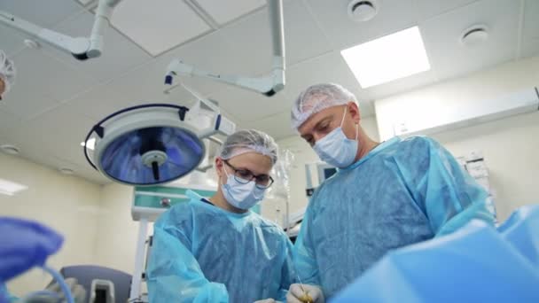 Grupa Lekarzy Wykonująca Operację Pacjencie Chirurdzy Mundurach Medycznych Maski Pracujące — Wideo stockowe