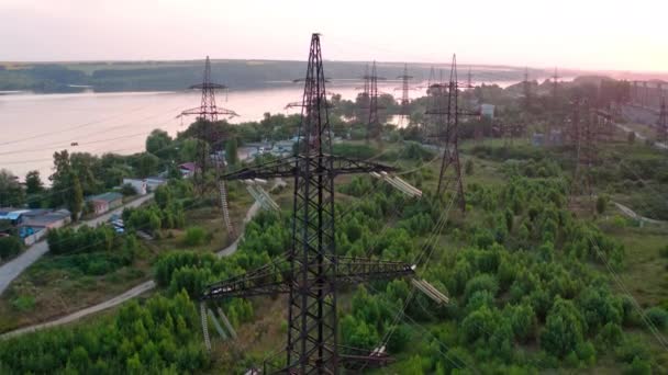 日落时城市外高压线路的结构 树和河 摄像头向后移动空中景观 — 图库视频影像