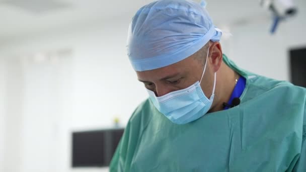 手術室のぼやけた背景にある外科医 プラスチック手術を行う医師の肖像画 プロフィールビュー — ストック動画