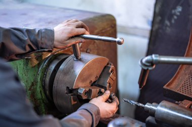 Metal, Oluşturma, Şekillendirme ve El Sanatları Üzerinde Çalışan Kişi. Metal işçiliği sanatında odaklanmış ve yetenekli bir birey, bir metal parçasıyla etkin bir şekilde şekillendiriyor ve yaratıyor..