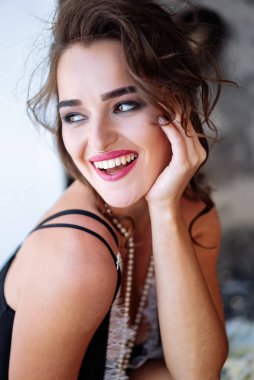 Yatakta Neşeli İfadesiyle Oturan Kadın. Yüzünde bir gülümsemeyle yatakta oturan bir kadın..