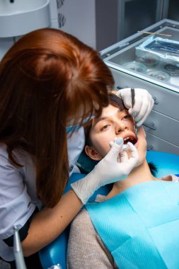 Kadın Dişçi Tarafından Kontrol Ediliyor, Stomatolia Diş Tedavisi Muayenesi. Bir kadın diş muayenesi ve Stomatolia 'da tedavi için dişçiye gider ve oral sağlığı sağlanır..