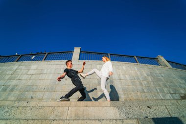 Birlikte Ayakta Duran, Gülümseyen, Açık Hava, Güneşli Gün. Bir çift insan merdivenlerde durup gülümsüyor, açık havada güneşli güzel bir günün tadını çıkarıyor..