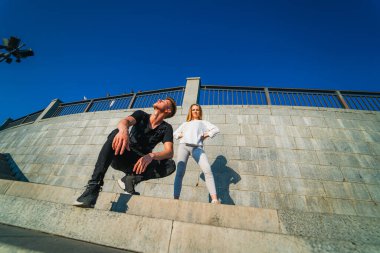 Erkek ve Kadın Basamaklarda Oturuyor - Güneşli bir günde Dışarıda Birlikte Rahatlıyor