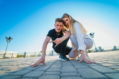 Erkek, kadının yanında diz çöküyor. Bir erkek, saygıyla kendini bir kadının yanına yerleştirir..